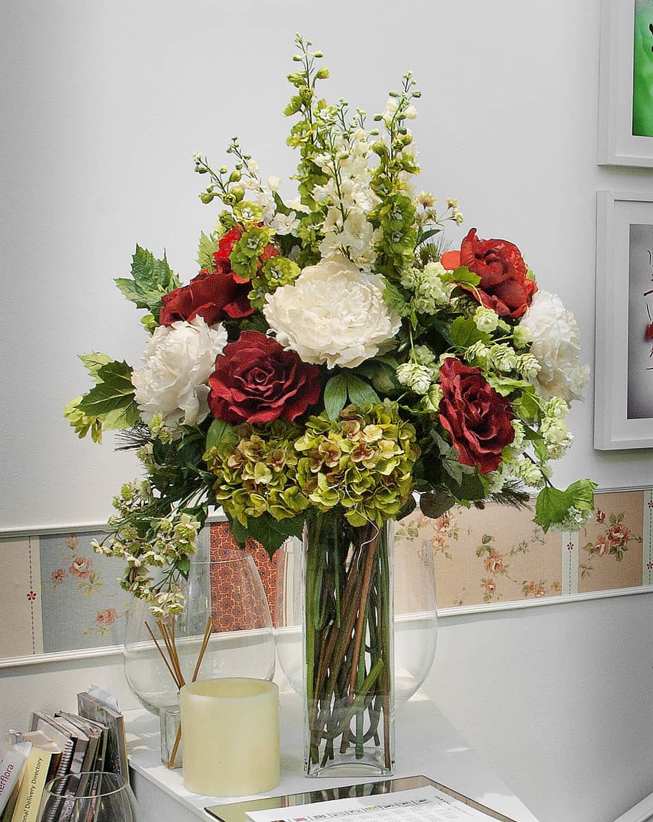 jarrón con varias flores artificiales como rosas blancas y rojas