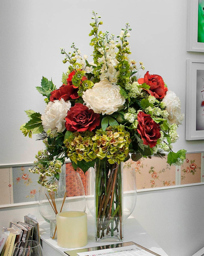 jarrón con varias flores artificiales como rosas blancas y rojas